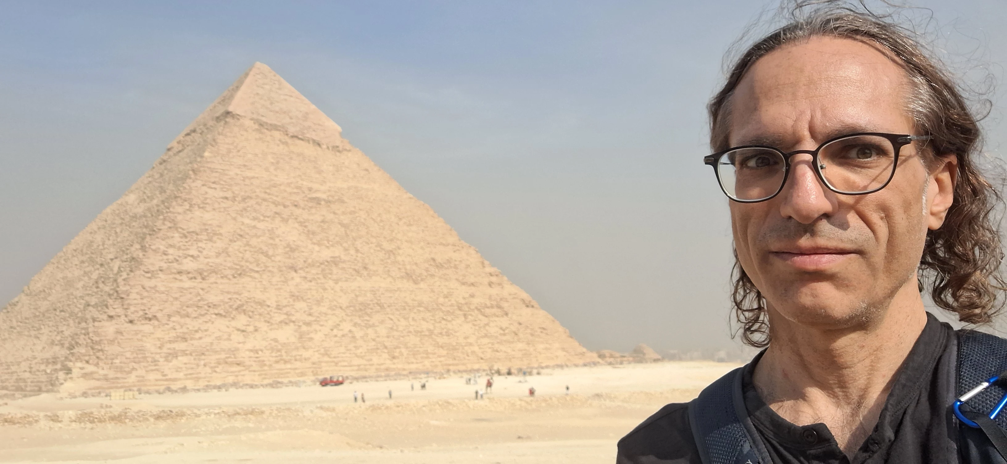 Richard Massel standing in the desert in front of the Great Pyramid of Giza.